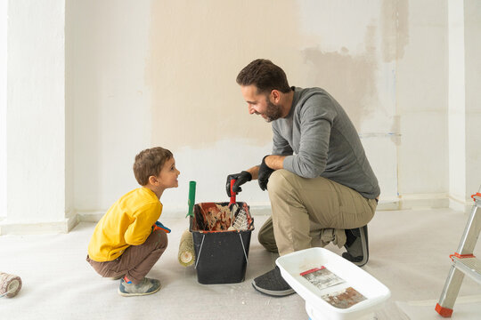 Father teaching son about home renovation painting