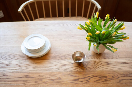 Simple Table Setting With Plates and Flowers in a Cozy Room