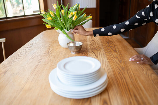 Setting a Table With Flowers and Plates for a Meal