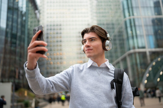 Young man takes selfie in city
