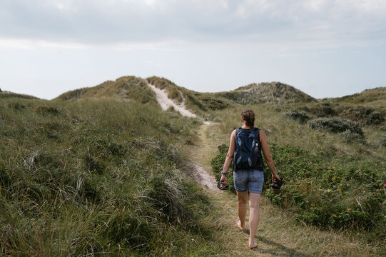 middle aged woman walking across dunes in Denmark 