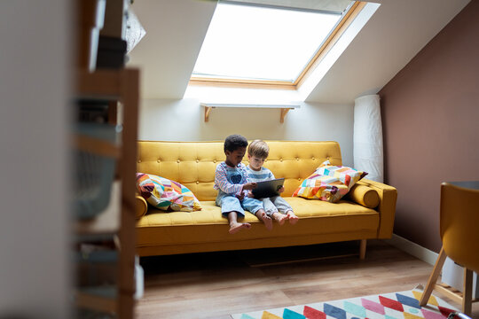Diverse children friends sharing a tablet at home