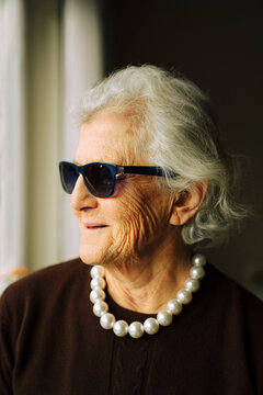 Portrait of a senior woman wearing a pearl necklace and sunglasses