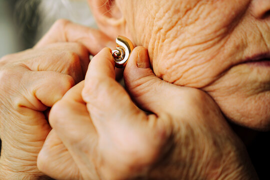Senior woman trying to put an earring
