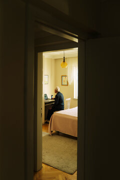 Senior man using computer in his room