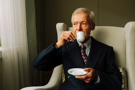 Portrait of senior man drinking Turkish coffee by the window
