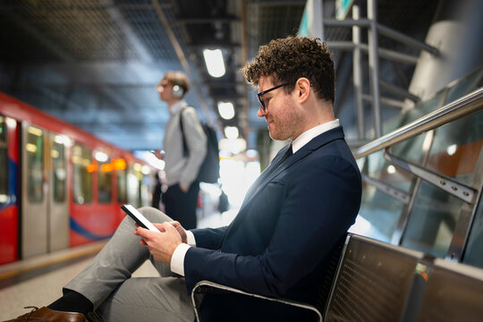 Man using phone at train station
