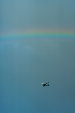 A commercial airplane on the background of the rainbow 