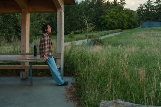 Woman standing near the picnic table in the grassland 