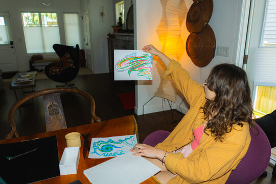 Woman drawing abstract pattern at home in the evening 