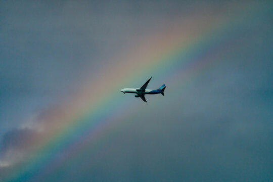 A commercial airplane on the background of the rainbow 