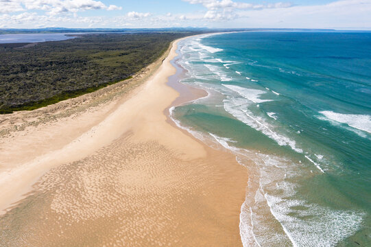 Gentle waves rolling onto a long sandy beach stretching to the horizon