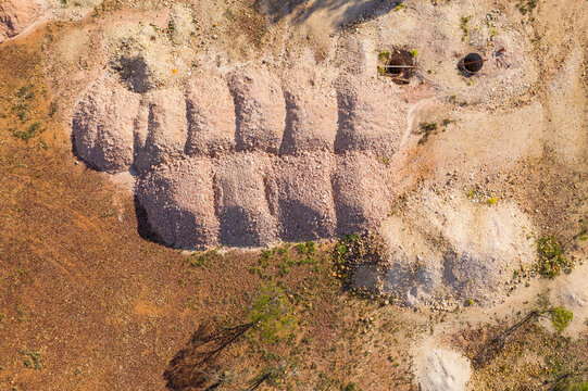 Dirt piles alongside opal mining holes in an arid outback landscape