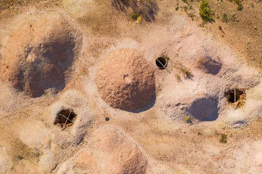 Dirt piles alongside opal mining holes in an arid outback landscape