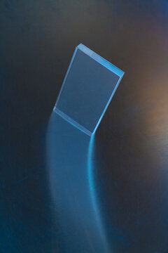 Glass Prism with Blue Light Reflection on Dark Surface