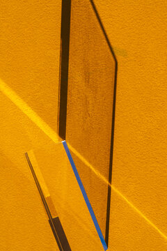 Glass Prism Refracting Sunlight on Yellow Textured Wall