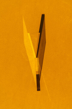 ertical Glass Prism Refracting Light on Yellow Textured Wall