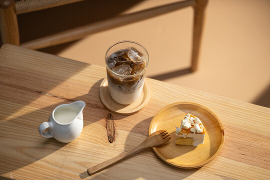 iced coffee and cake on a wooden table in natural sunlight