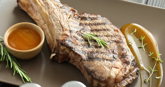 Tasty beef steak served on wooden table, spinning