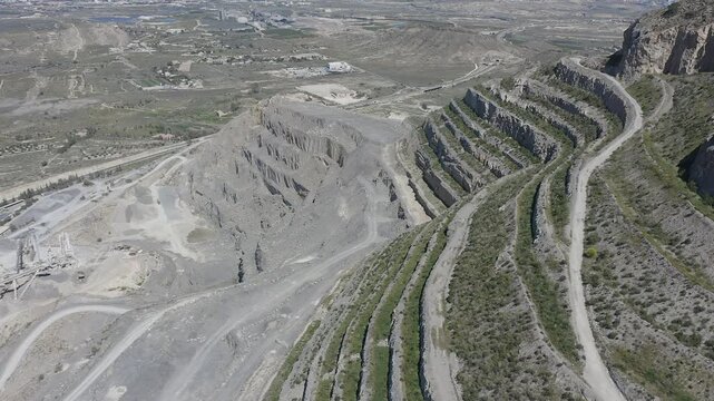 Aerial view of a cement quarry with special vehicles assisting in rock extraction in Spain.