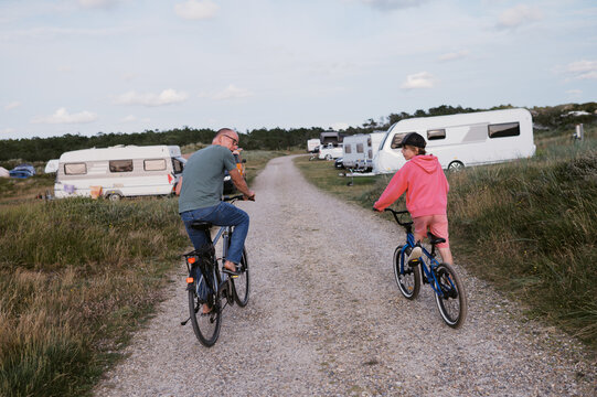 grandfather and grandson biking together at campground in denmark