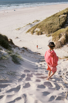 boy on top of huge dune in b&oslash;rsmose denmark looking at sister