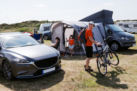 man with bike returning to family and campsite in Denmark