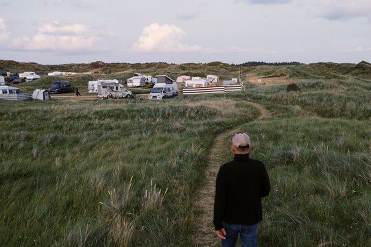 man on vacation walking toward campsite among dunes