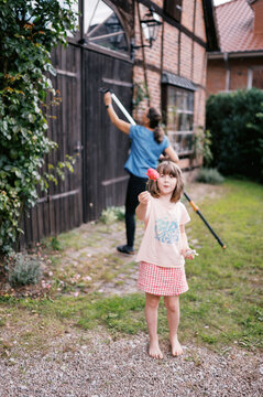 middle aged woman pruning tall climbing rose in germany