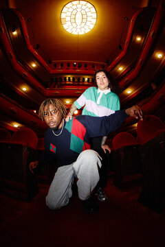 Young adults pose in theater with bright colors and stylish outf