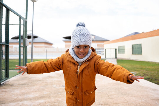 Happy little girl running outdoor enjoying winter fun