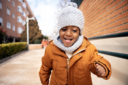 Happy little girl running outdoor enjoying winter fun