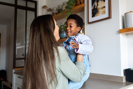 Mother and adopted daughter bonding in kitchen