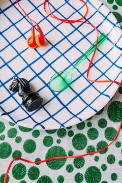 Colorful objects on a grid plate with red and green background