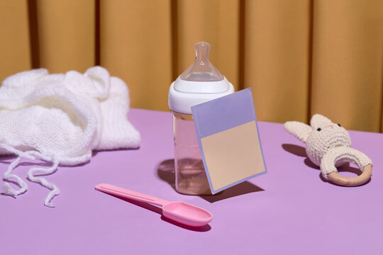 Baby feeding essentials including a bottle, spoon, and soft hat