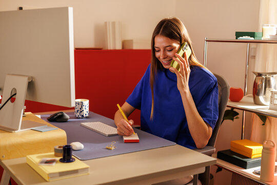 Woman in Blue Shirt Using Phone at Home, Embracing a Modern Lifestyle