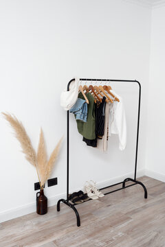 Clothes on a Rack With Pants and Tops in a Bright Room