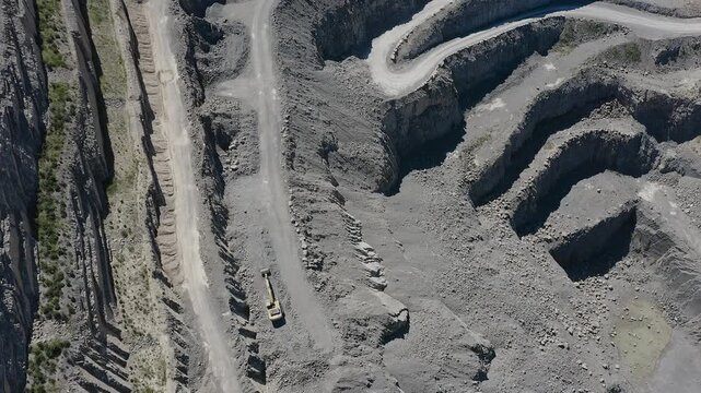 Aerial view of a cement quarry with special vehicles assisting in rock extraction in Spain.