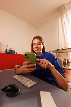 Woman enjoying lifestyle at home workspace with smartphone