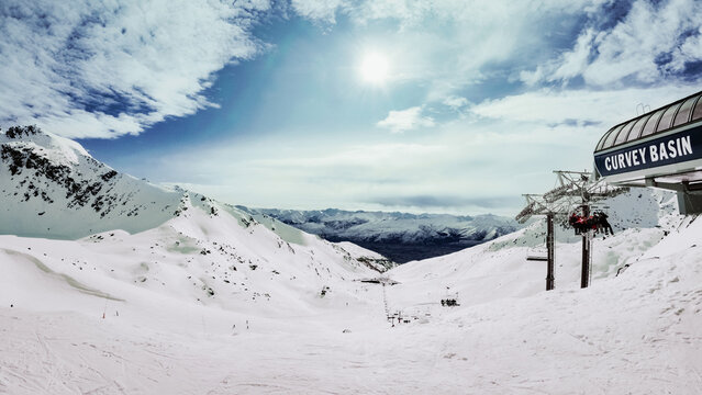 Piste enneig&eacute;e avec panneau Cornet Basin et mer de nuages sous ciel bleu &agrave; la station de ski de Remarkables, &icirc;le du Sud, Nouvelle-Z&eacute;lande
