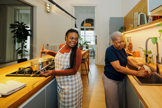Family members cooking and cleaning in kitchen