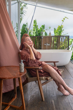 Woman Relaxing in Robe Near Outdoor Bathtub at Tropical Villa