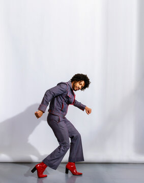 Person in Stylish Outfit Dances in Front of White Backdrop