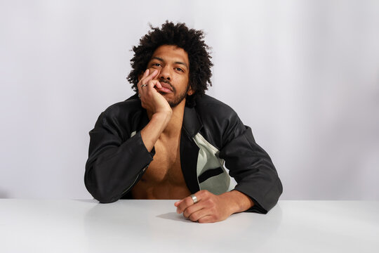 Man Sitting at Table With Thoughtful Expression Indoors
