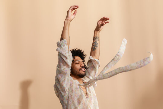 Man Dancing With Arms Raised and Fabric Flowing 
