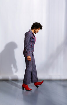 Person Walks in Red Shoes on a Plain Background in a Studio Setting