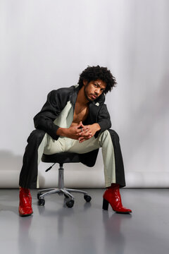 Man Seated on Chair in Stylish Outfit 