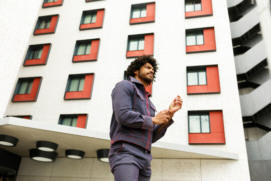 Man Wears Casual Outfit Outside Modern Building in Urban Area