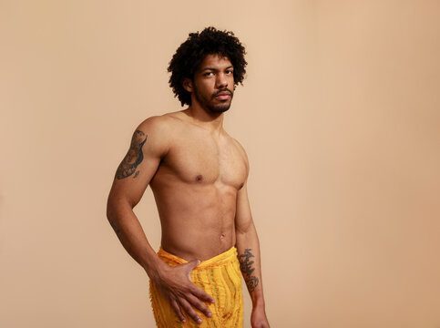 Man Poses in a Studio Wearing Yellow Pants