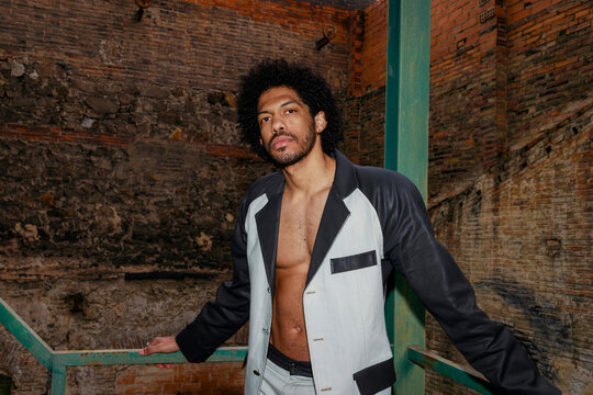 Man Poses on Balcony Wearing a Black and White Jacket 